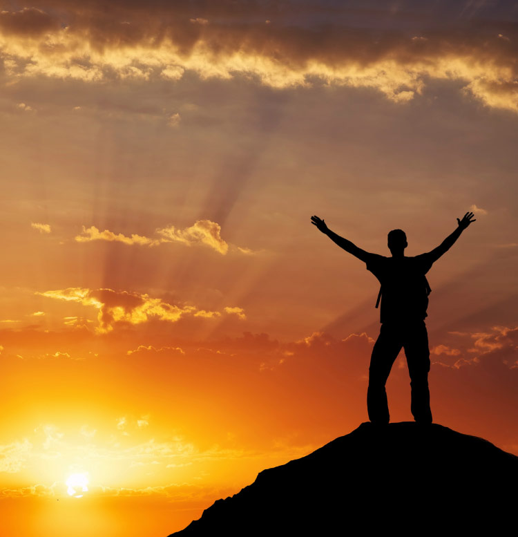 hombre en la cima de una montaña, demostrando felicidad